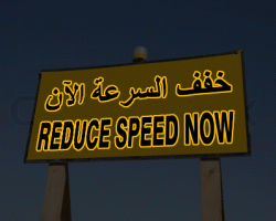 Reduce Speed Now sign in english and arabic language. Dubai, United Arab Emirates